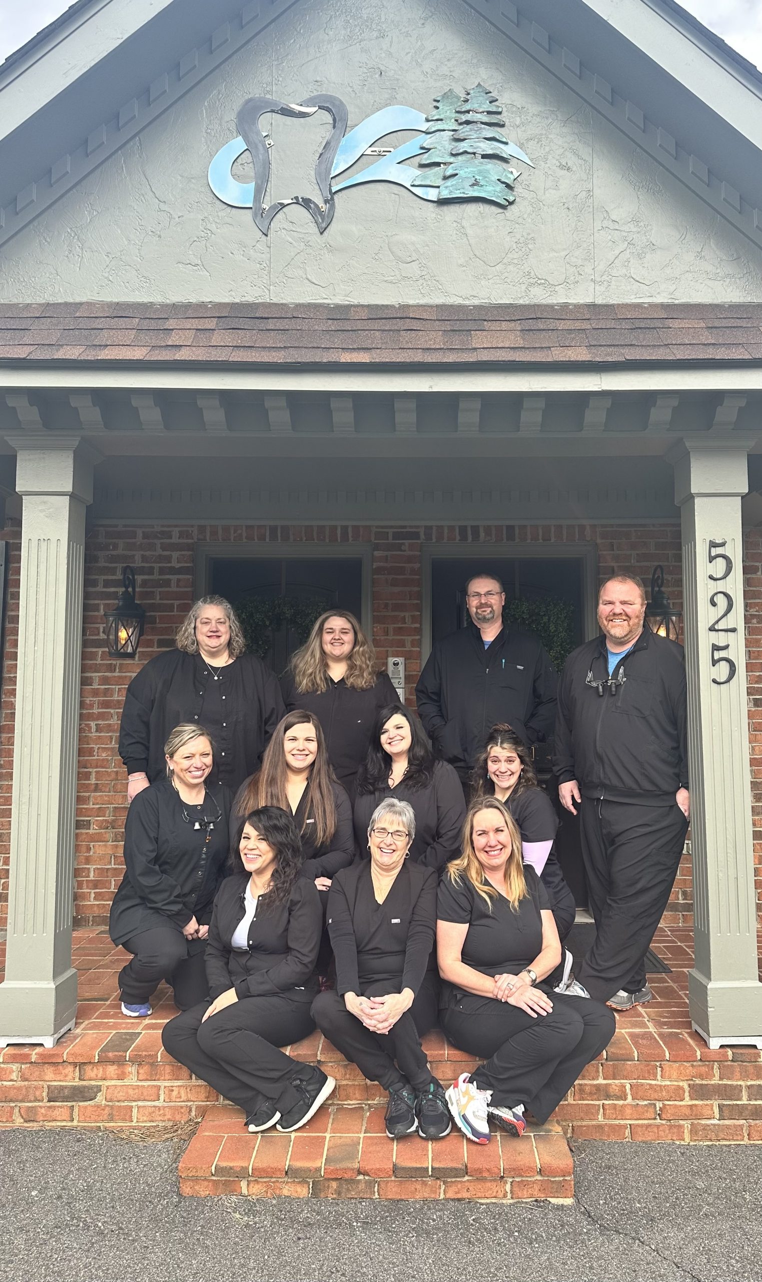 Joel W. Yates Jr. DDS team posed in front of the dental office